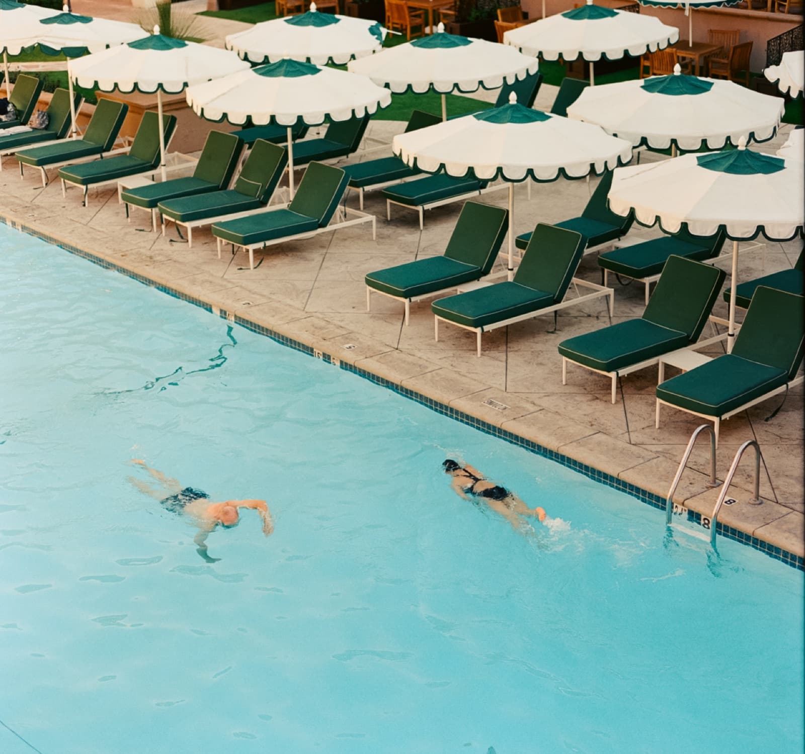 Lounge chairs lined up beside a hotel pool