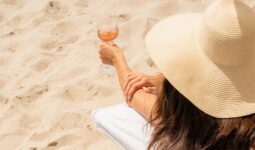 Woman on the beach holding a glass of Whispering Angel