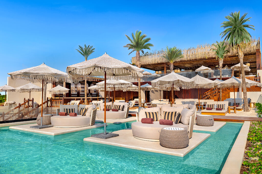 Piscina y palapas del Ennea Beach Club en la Zona Hotelera de Cancún