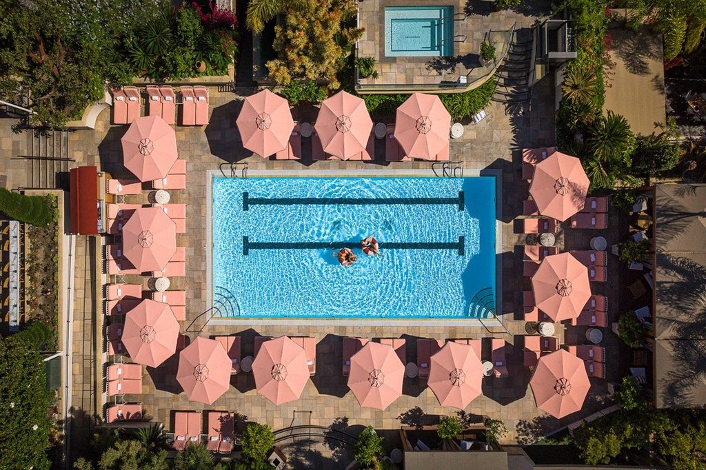 Aerial view of the rooftop pool and pink umbrellas at Four Seasons Hotel Los Angeles at Beverly Hills